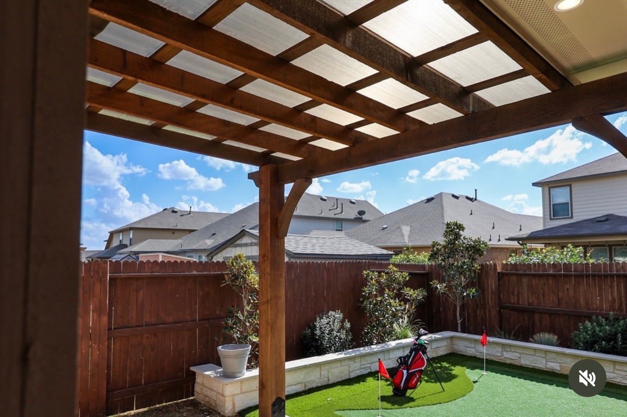 Cedar pergola with a polycarbonate roof over a backyard patio in San Antonio