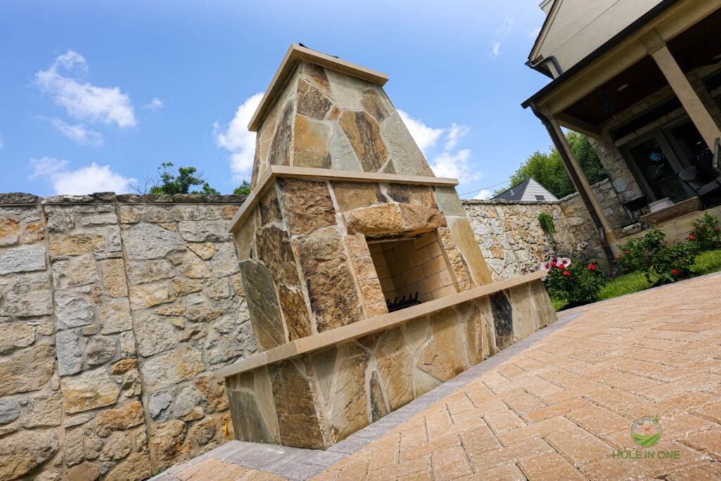 Outdoor stone fireplace in backyard patio