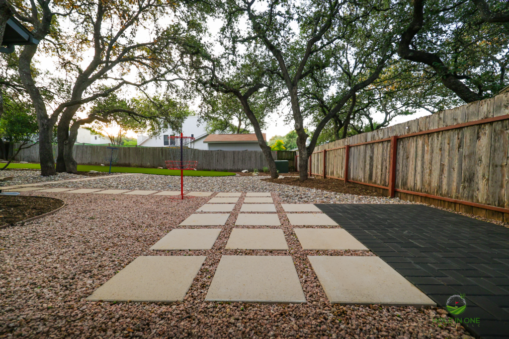 Wide-angle view of a stepping-pad gravel path under live oaks