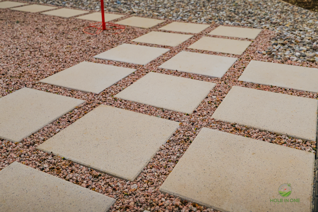 Close-up of large concrete pavers in red-tan pea gravel