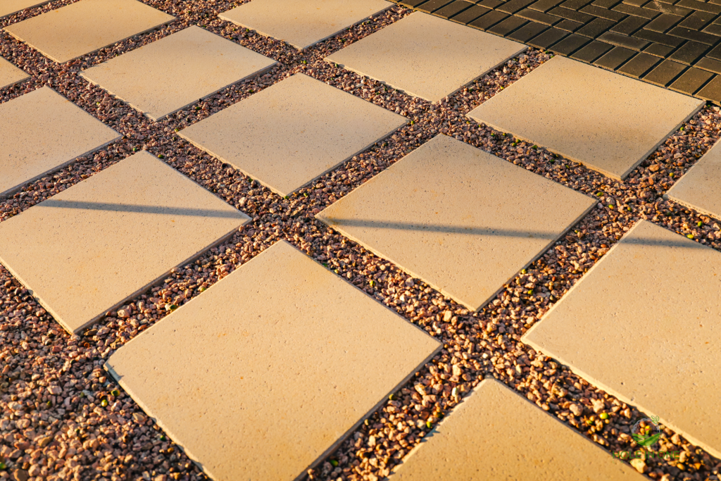 Close-up of square concrete pavers set in pea gravel joints