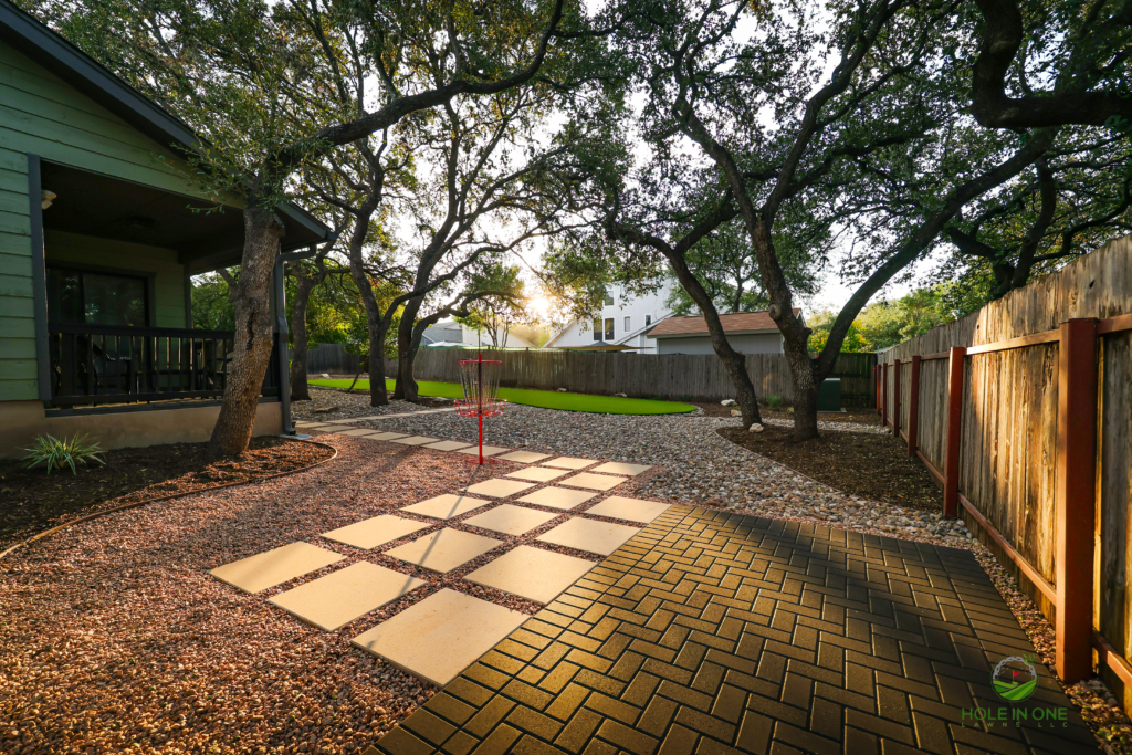 Stepping-pad path in decomposed gravel connecting a brick paver patio to a disc golf basket