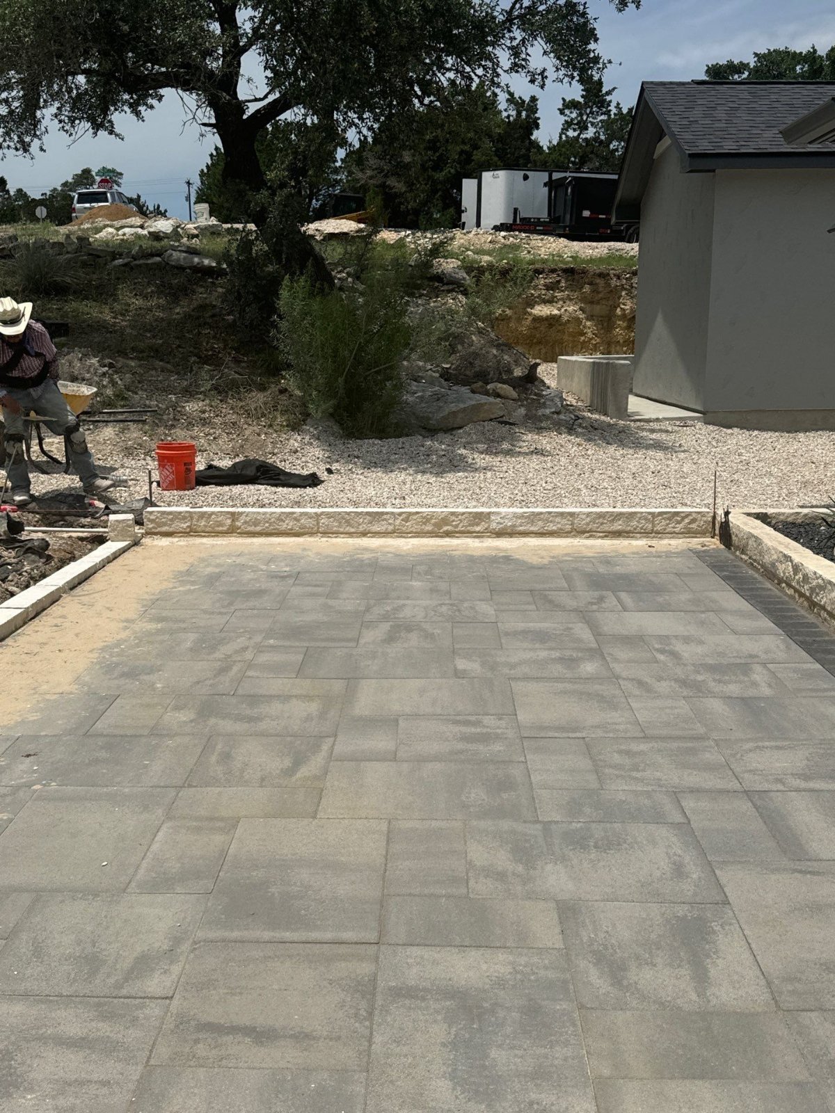 Gray Belgard paver patio with limestone edging under Hill Country oaks in Canyon Lake, TX