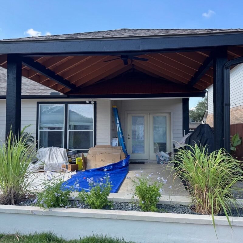 New covered patio pavilion behind a raised planter with ornamental grasses in Cibolo, TX