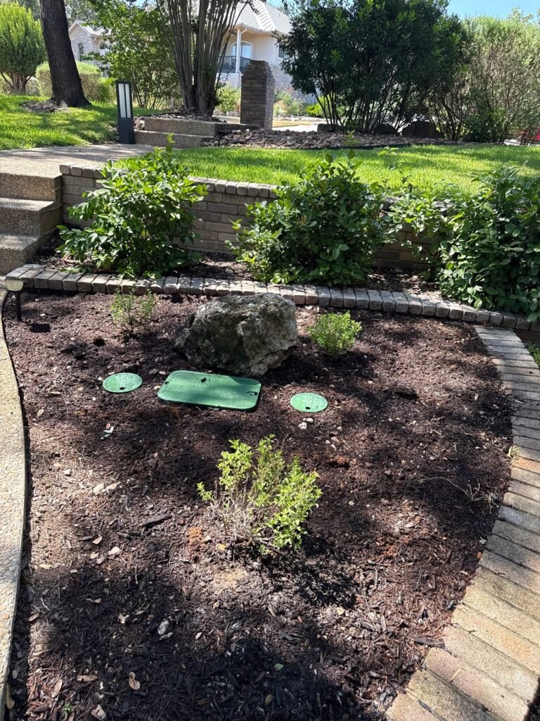 Mulched shrub bed with paver edging next to limestone retaining wall and steps in Fair Oaks Ranch, TX