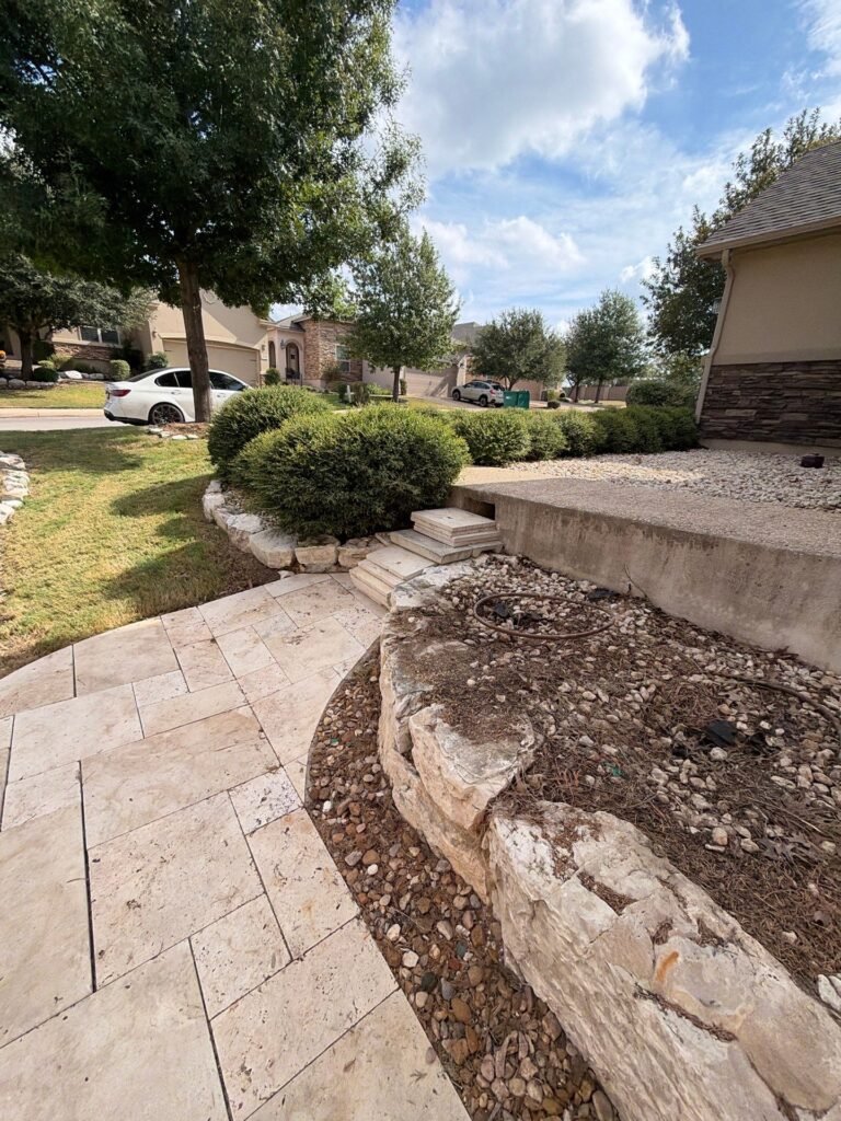 Travertine walkway with limestone block steps and boulder-edged planting bed in Stone Oak, North San Antonio
