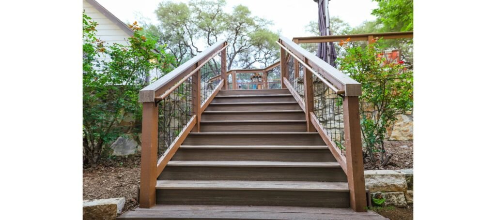 Trex composite staircase with wire-panel railing climbing a hillside