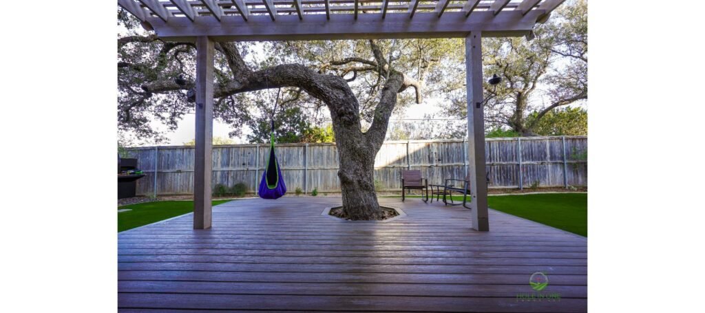 Trex composite deck built around a live oak with an open tree cutout, under a pergola in San Antonio