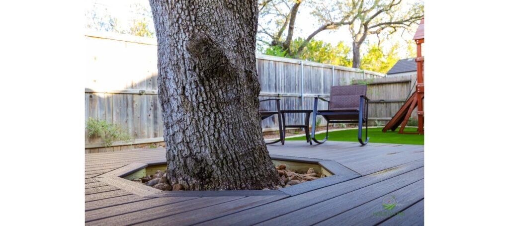 Custom tree cutout in a Trex deck with a river rock border to protect the live oak trunk